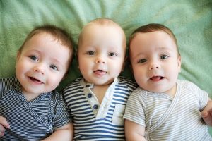 Portrait of newborn triplets are lying in the bed